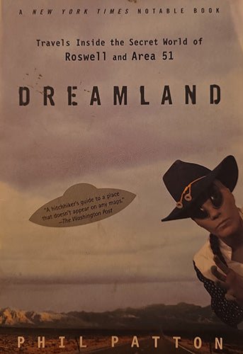 Book cover for 'Dreamland' by Phil Patton, featuring a sepia-toned desert landscape, a cowboy in a black hat and sunglasses, and a UFO with a quote on it.