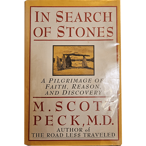 The book cover titled "In Search of Stones" by M. Scott Peck, M.D., features a beige background with red text. A small illustration of standing stones is centered. The subtitle reads, "A Pilgrimage of Faith, Reason, and Discovery." At the bottom, it notes the author of "The Road Less Traveled."