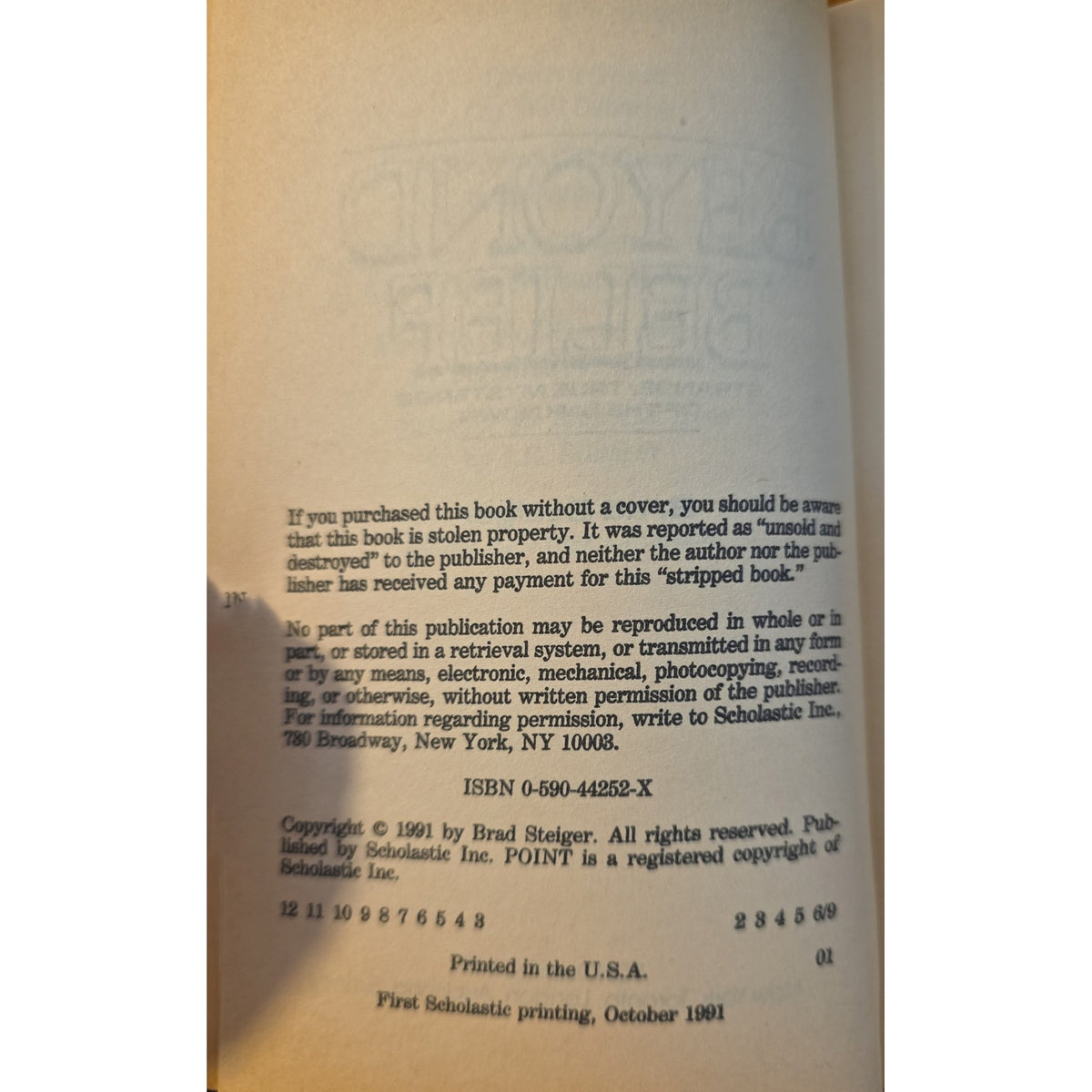 A close-up of a book's interior copyright page, showing printed text on aged cream paper. Visible publisher text includes 'Published by Scholastic Inc.