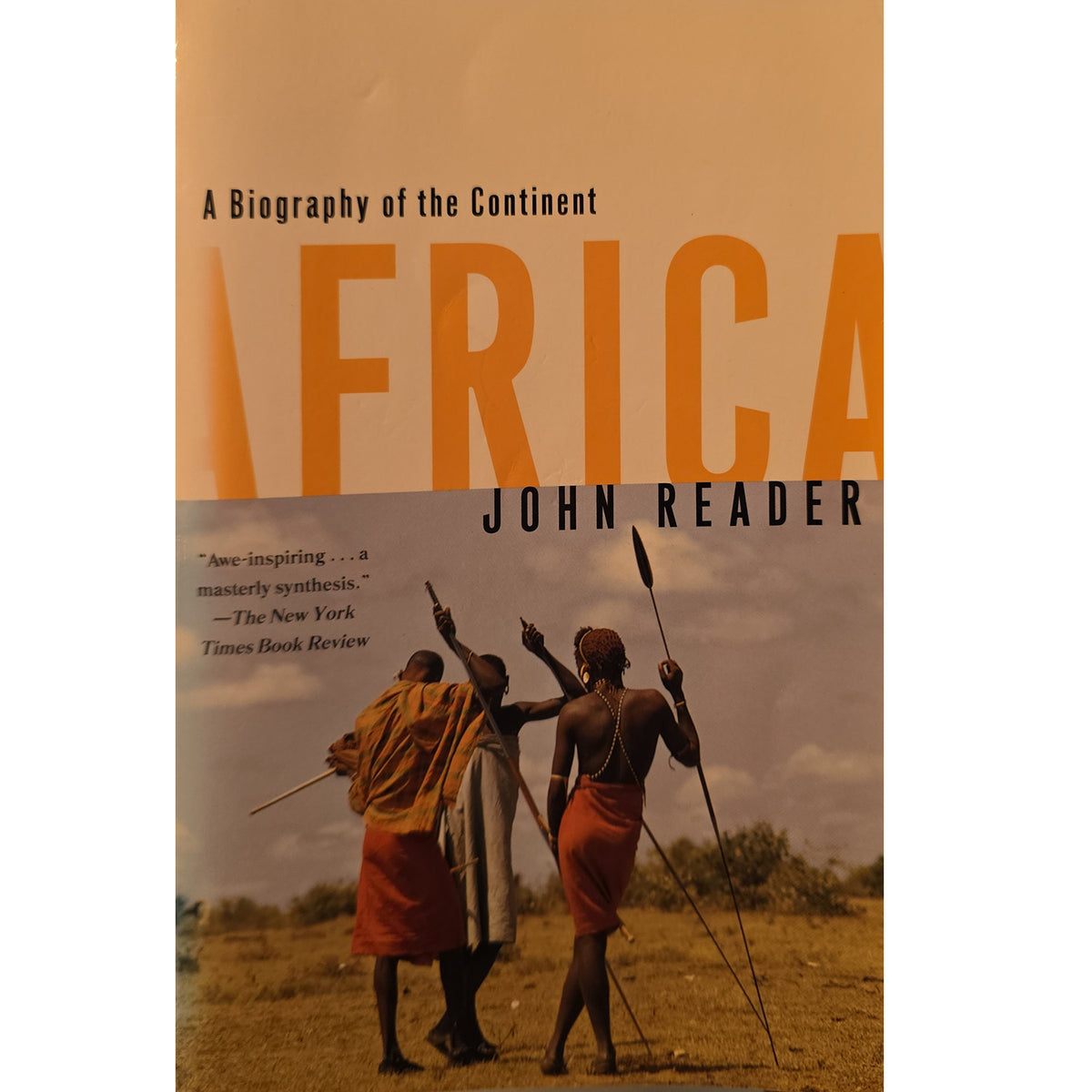 Front cover of John Reader’s Africa: A Biography of the Continent, showing three people walking across a landscape.