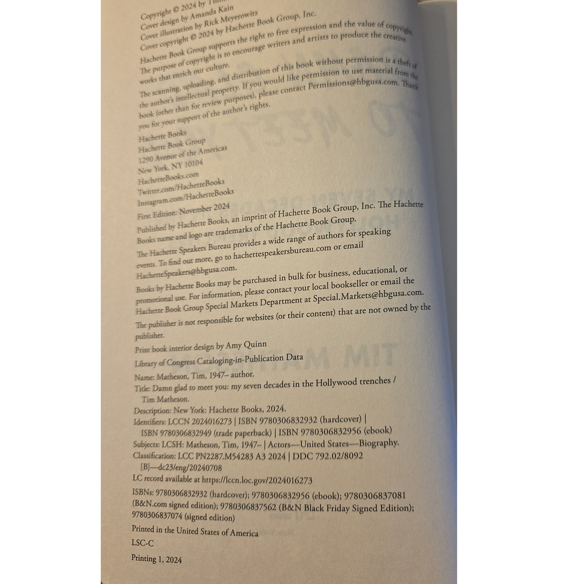 A close-up of a printed book or booklet page showing copyright and publisher text, photographed against a dark background.