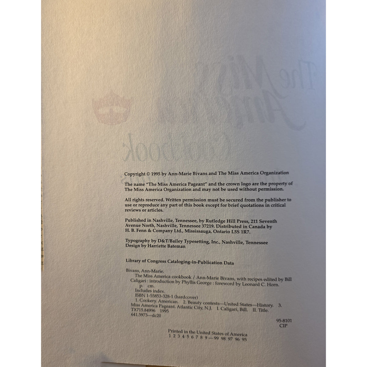 A close-up of a vintage book's printed copyright page, showing black text on aged beige paper with a faint embossed logo in the background.