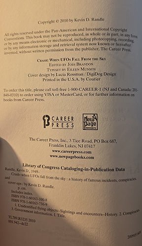 A photographed bookcopyright or publication back cover with printed text, publisher logos, and a New Page mark on a light beige background.