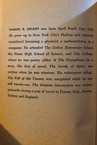 A close-up of printed text on a beige book or paper page, with warm sunlight casting shadows across the surface.