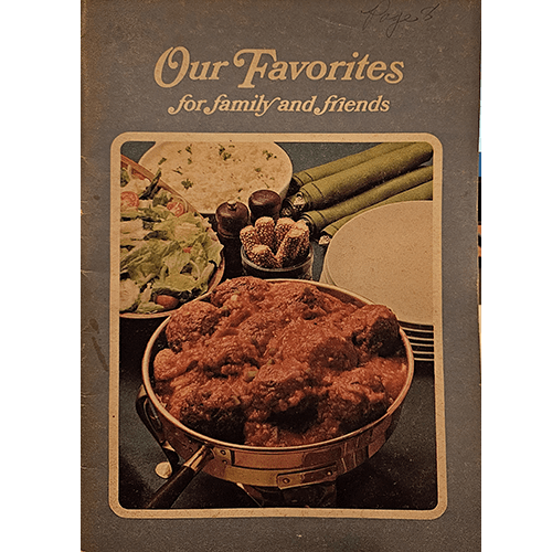 The cover of Our Favorites for Family and Friends features a serving of hearty stew in a rustic pan, accompanied by a salad and rice. The text is in warm cream tones, capturing a homey, welcoming vibe.