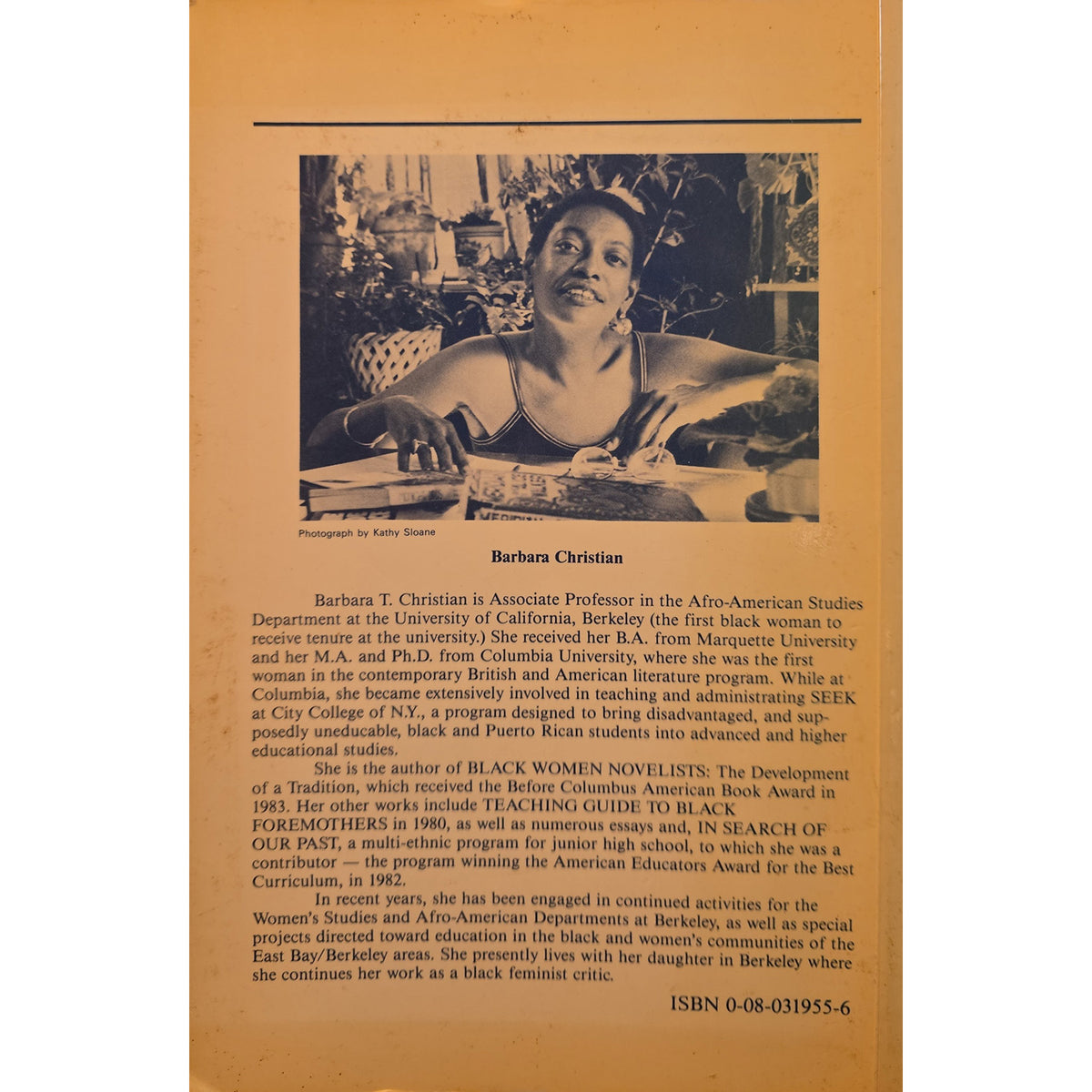 The back cover of a book featuring a brown wood-grain textured background with black text and a small black-and-white photograph near the top.