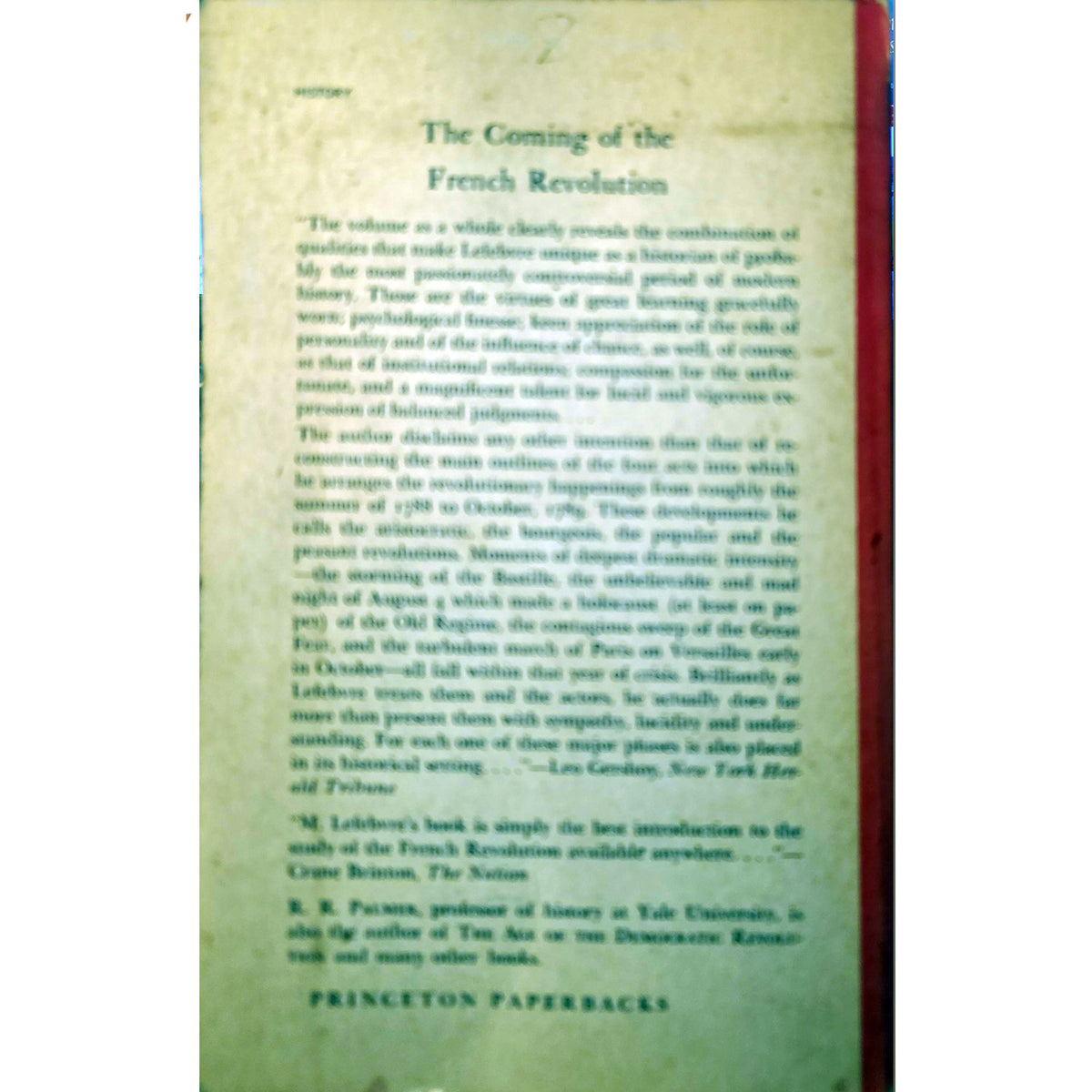 A vintage book page titled 'The Coming of the French Revolution' printed on aged beige paper with a red binding edge visible on the right, photographed against a dark background.