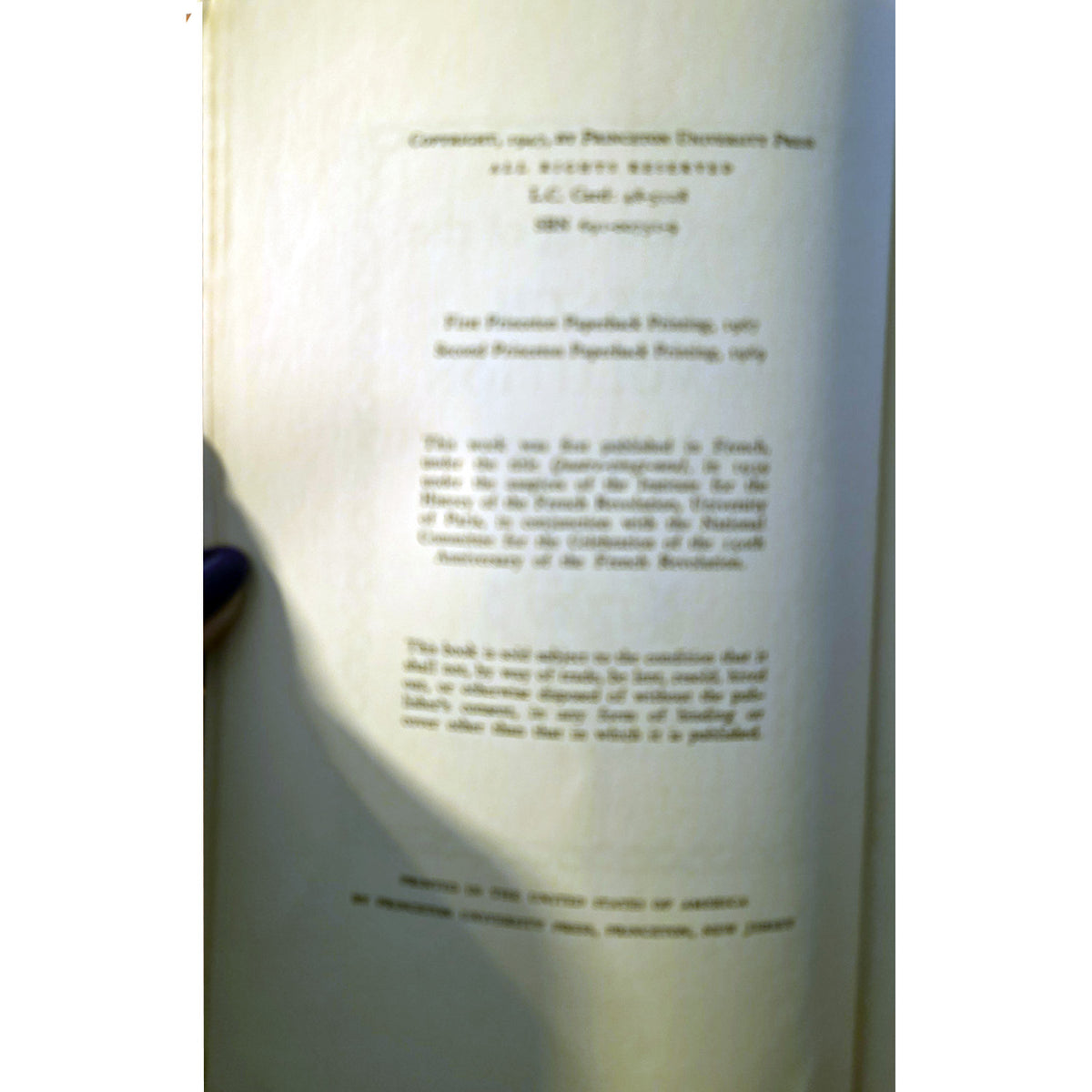 A close-up of a book's printed title page with French text, photographed against a white background.