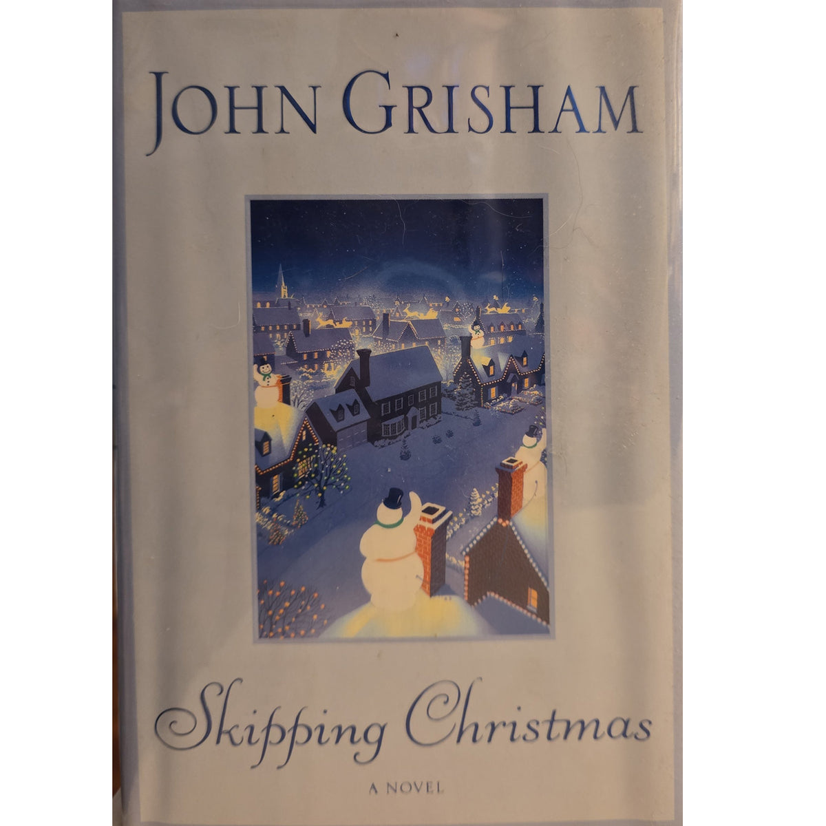 John Grisham's novel 'Skipping Christmas' on a light beige background with a central winter village illustration.