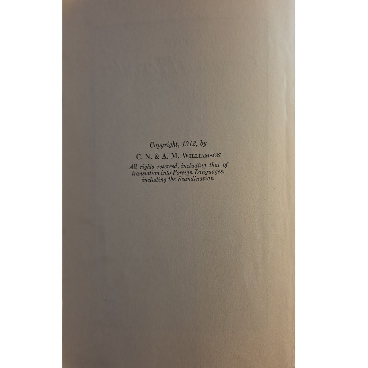 A close-up of a book's copyright page, showing black printed text on a warm beige or light brown paper background.