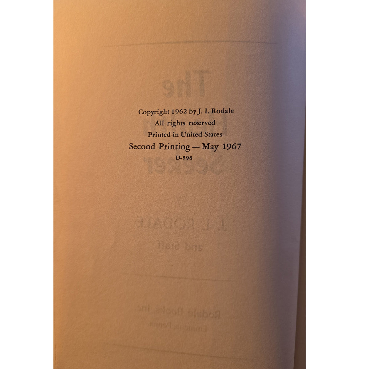 A close-up of a book's title page or copyright page with black printed text on a warm tan paper background.