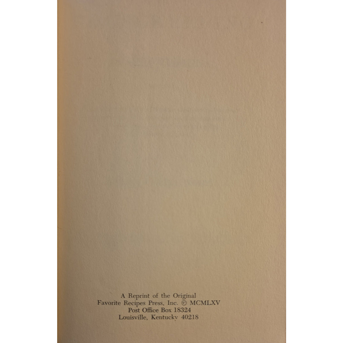 A close-up of a beige paper surface with small black printed text at the bottom reading, 'A Reprint of the Original Favorite Recipes Press, Inc. © MCMLXV Post Office Box 18254 Louisville, Kentucky 40215.