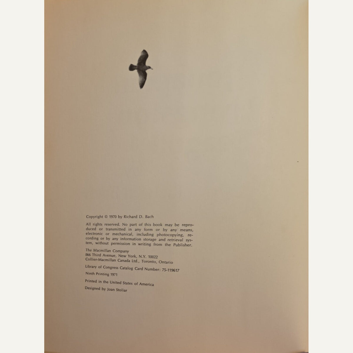 A vintage book's copyright page on warm beige paper, featuring a black bird silhouette near the top and small publisher and copyright text at the bottom.