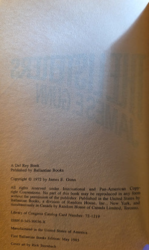 A close-up of a book's interior title page with printed copyright and publisher text on aged beige paper, partially shadowed on the right side.