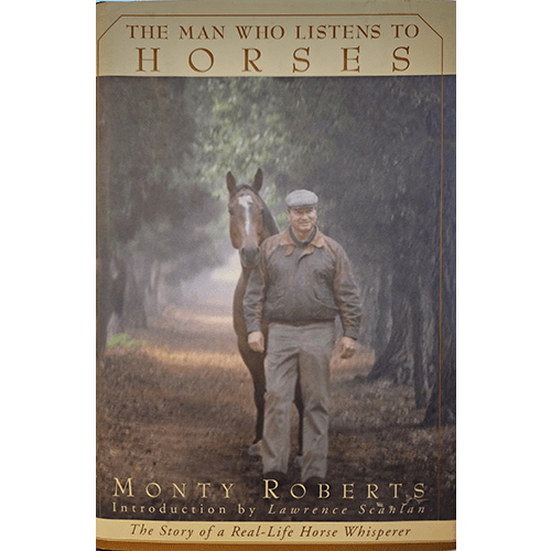 Cover of The Man Who Listens to Horses by Monty Roberts, featuring Roberts walking beside a horse down a misty tree-lined path, symbolizing his gentle approach to training and connection with horses.