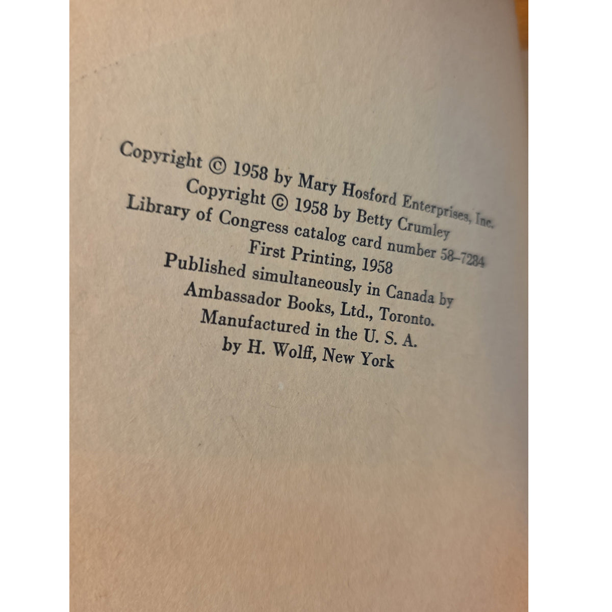 A close-up of a book's printed copyright page on warm beige paper, showing black text with publication details including 'Copyright © 1958 by Mary Hosford Enterprises, Inc.' and 'Published simultaneously in Canada by Ambassador Books, Ltd.