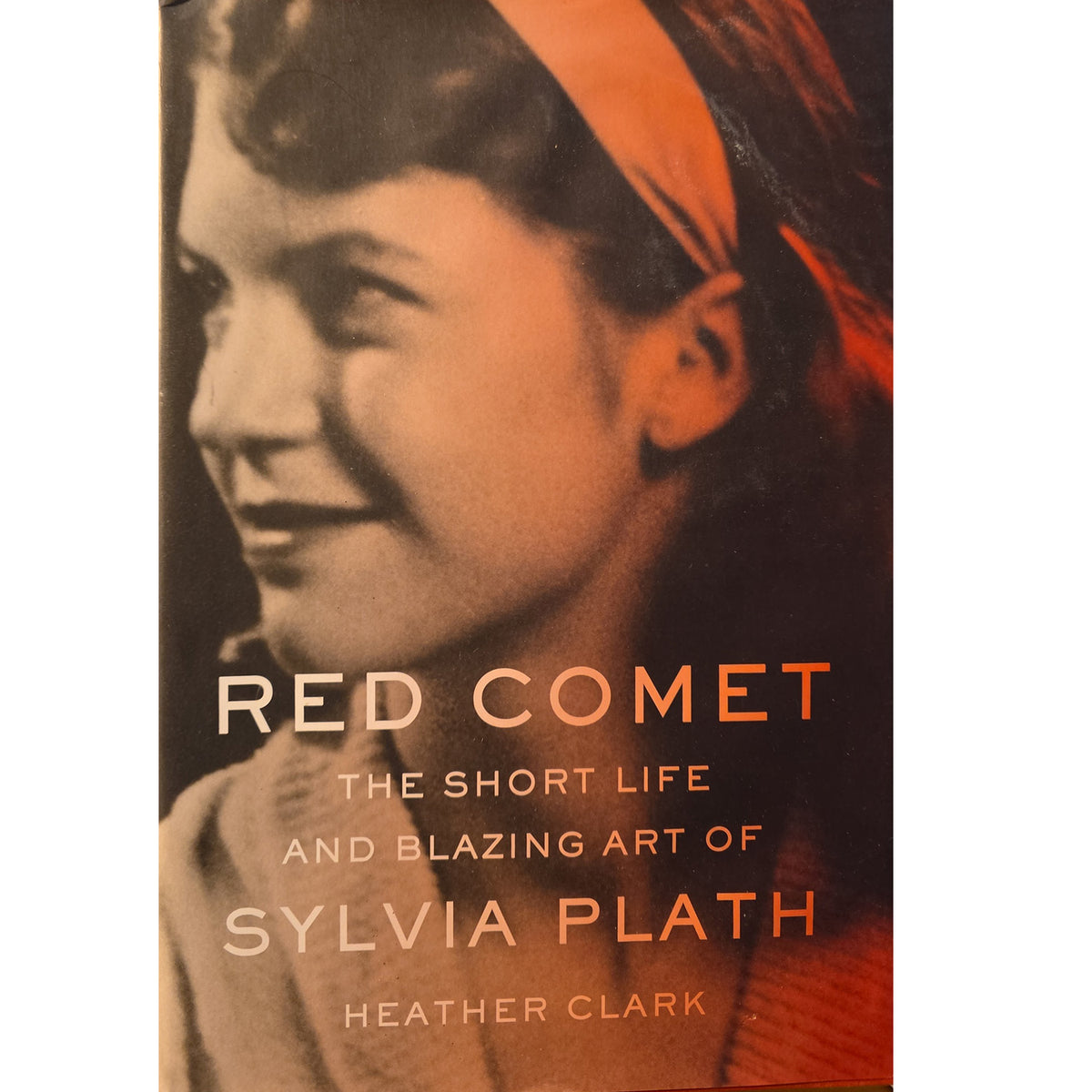Book cover for 'Red Comet: The Short Life and Blazing Art of Sylvia Plath' by Heather Clark, featuring a sepia-toned portrait of Sylvia Plath with orange text and a red-orange headscarf.