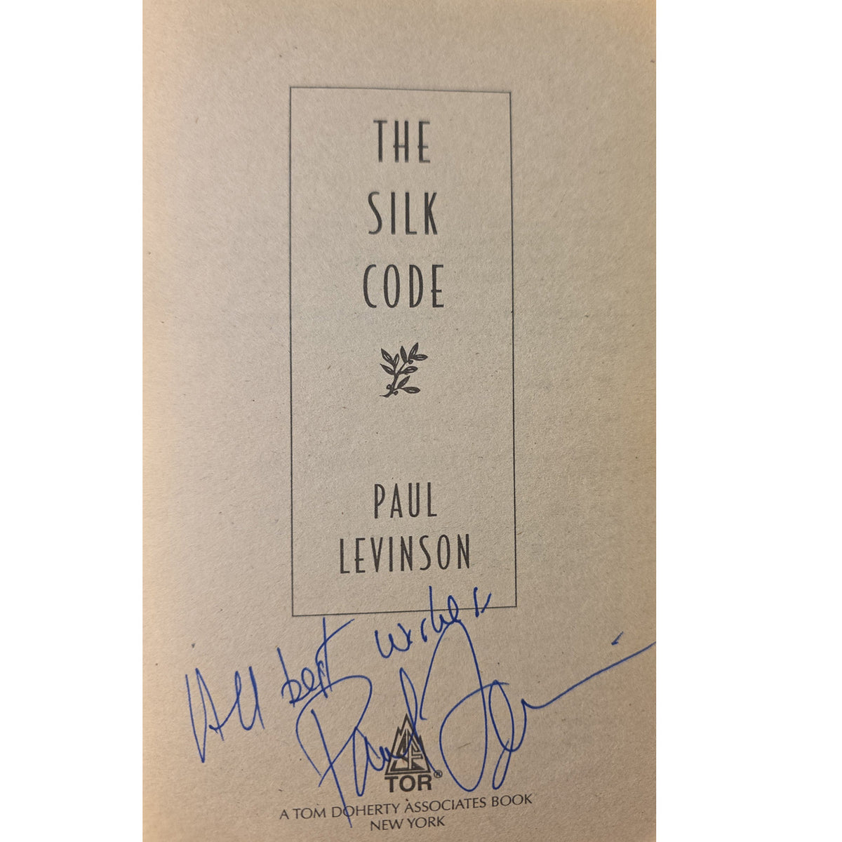 half title of the book 'The Silk Code' by Paul Levinson, featuring a beige background with black text and a blue handwritten signature at the bottom.