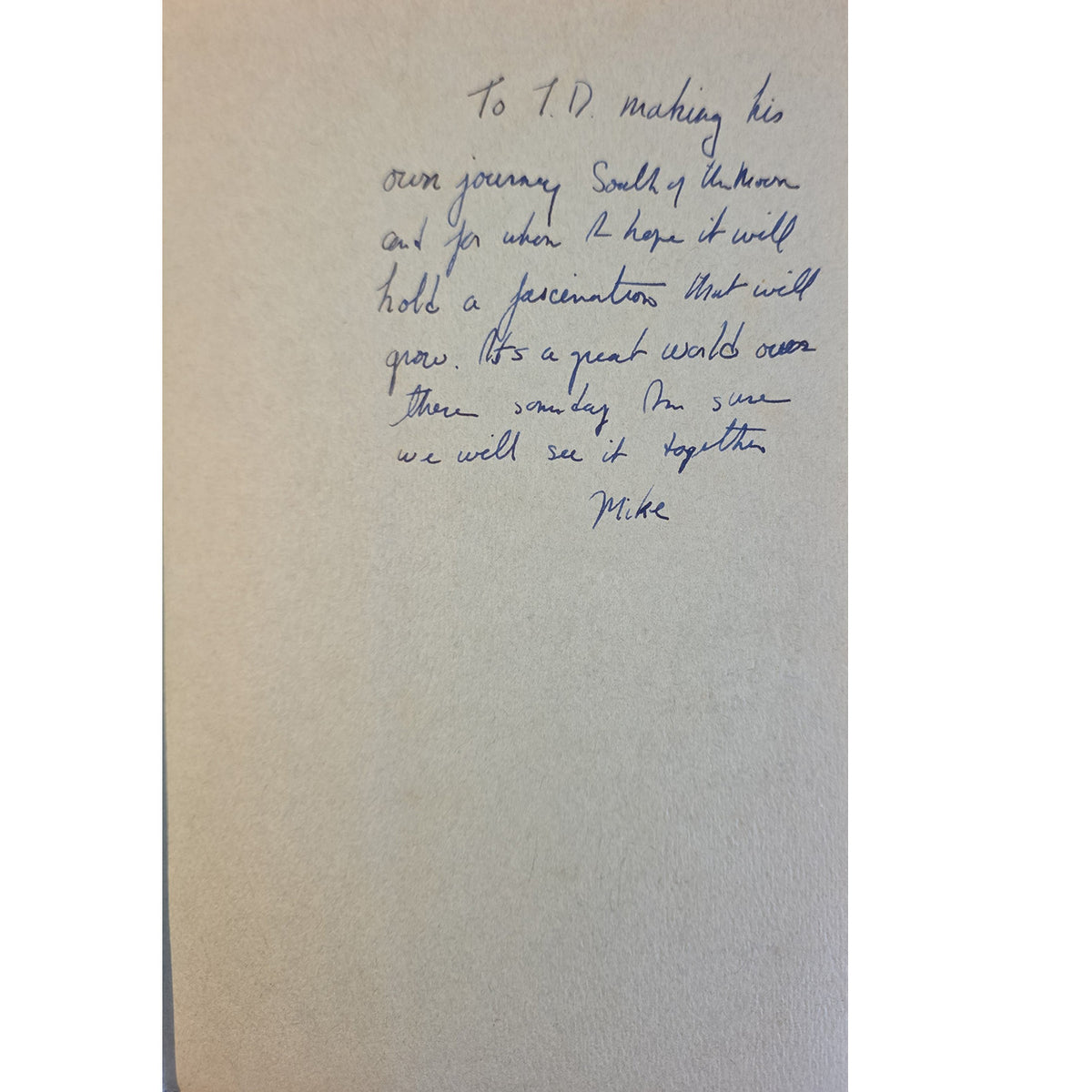 A handwritten letter on a beige card or envelope, written in blue ink, addressed to 'J.D.
