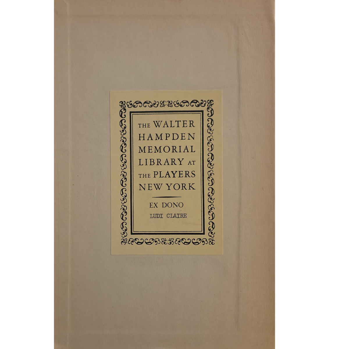 A vintage book or volume with a tan cloth or paper cover, featuring a centered cream label with black decorative border and text reading 'The Walter Hampden Memorial Library at the Players New York' and 'Ex Dono Louis Cladis.'.
