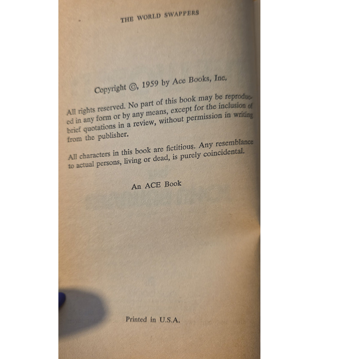 A vintage book page from 'The World Swappers' showing copyright details from Ace Books, Inc., dated 1959, printed on aged beige paper.