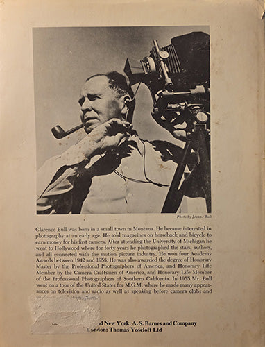 A vintage black-and-white printed page featuring a portrait of film photographer Clarence Bull, a large vintage movie camera, and biographical text below, photographed on aged off-white paper.