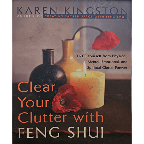 The cover of Clear Your Clutter with Feng Shui features a dimly lit scene with vases, a lit candle, and a red poppy flower, symbolizing the serene and transformative aspects of Feng Shui.