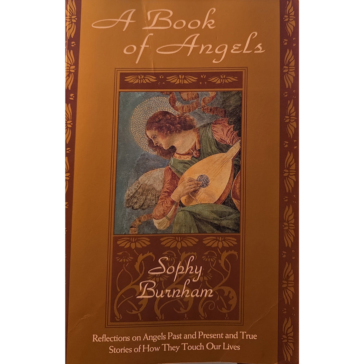 The front cover of the book 'A Book of Angels' by Sophy Burnham, featuring a warm brown and gold design with an illustration of an angel playing a lute.