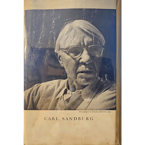 Book cover with a portrait of Carl Sandburg and a blue watercolor background