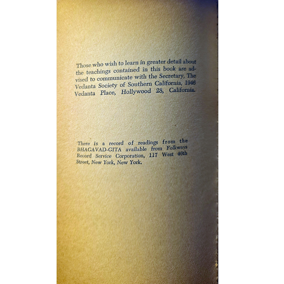 A close-up of a beige or tan textured paper or card with printed black text, photographed against a white background with a dark vertical edge visible on the right.