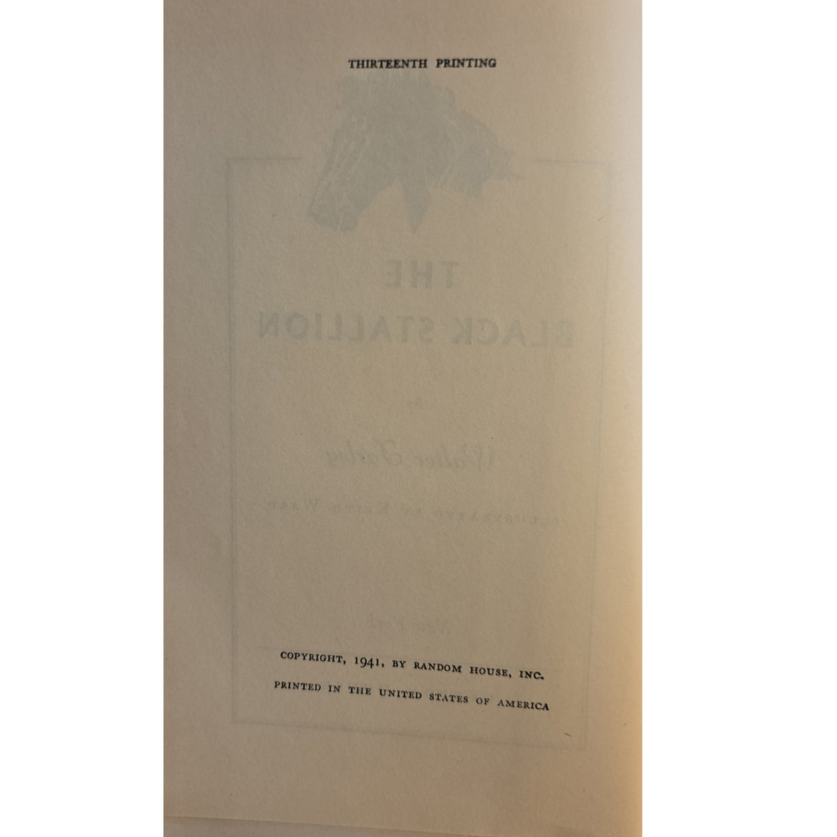 A vintage paper insert or title page from 'The Black Stallion' showing faded gray printed text and a horse silhouette on an aged cream background.