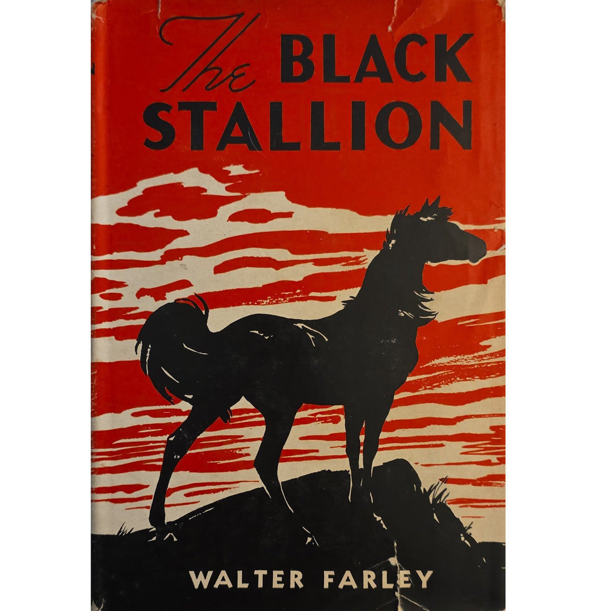 The Black Stallion by Walter Farley, vintage dust jacket featuring a black horse against a red and cream sky.