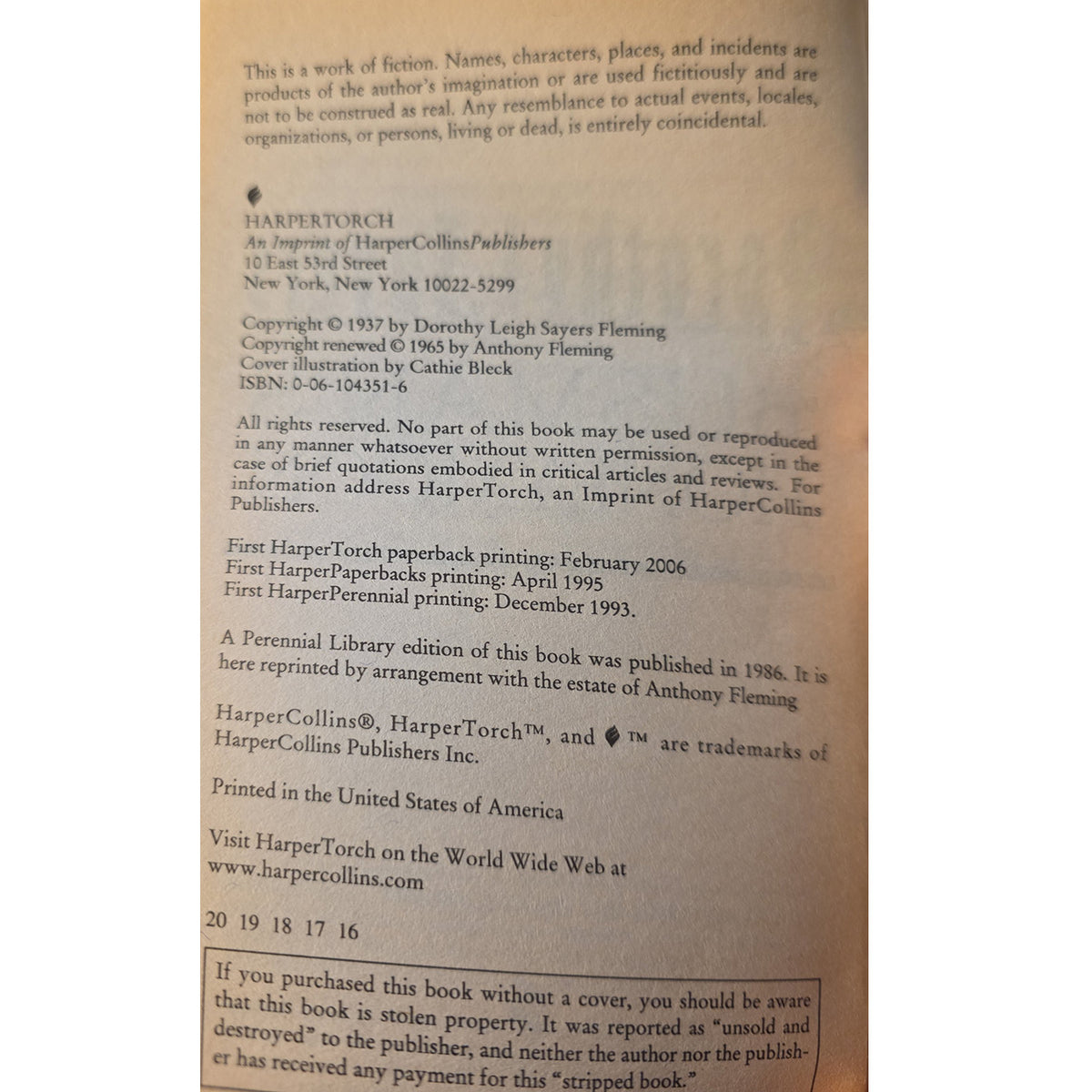 A close-up of a book showing printed copyright and publisher information for HarperCollins Publishers and HarperTorch.