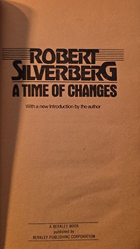 A close-up of a book cover or printed page with the title 'ROBERT SILVERBERG A TIME OF CHANGES' in large black text on a warm tan background. Smaller text below reads 'With a new Introduction by the author' and the bottom line mentions Berkley Book / Berkley Publishing Corporation.