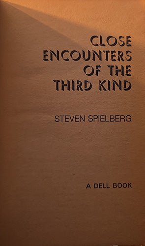 Book cover for 'Close Encounters of the Third Kind' by Steven Spielberg, published by Dell Book, featuring black text on a textured brown background.