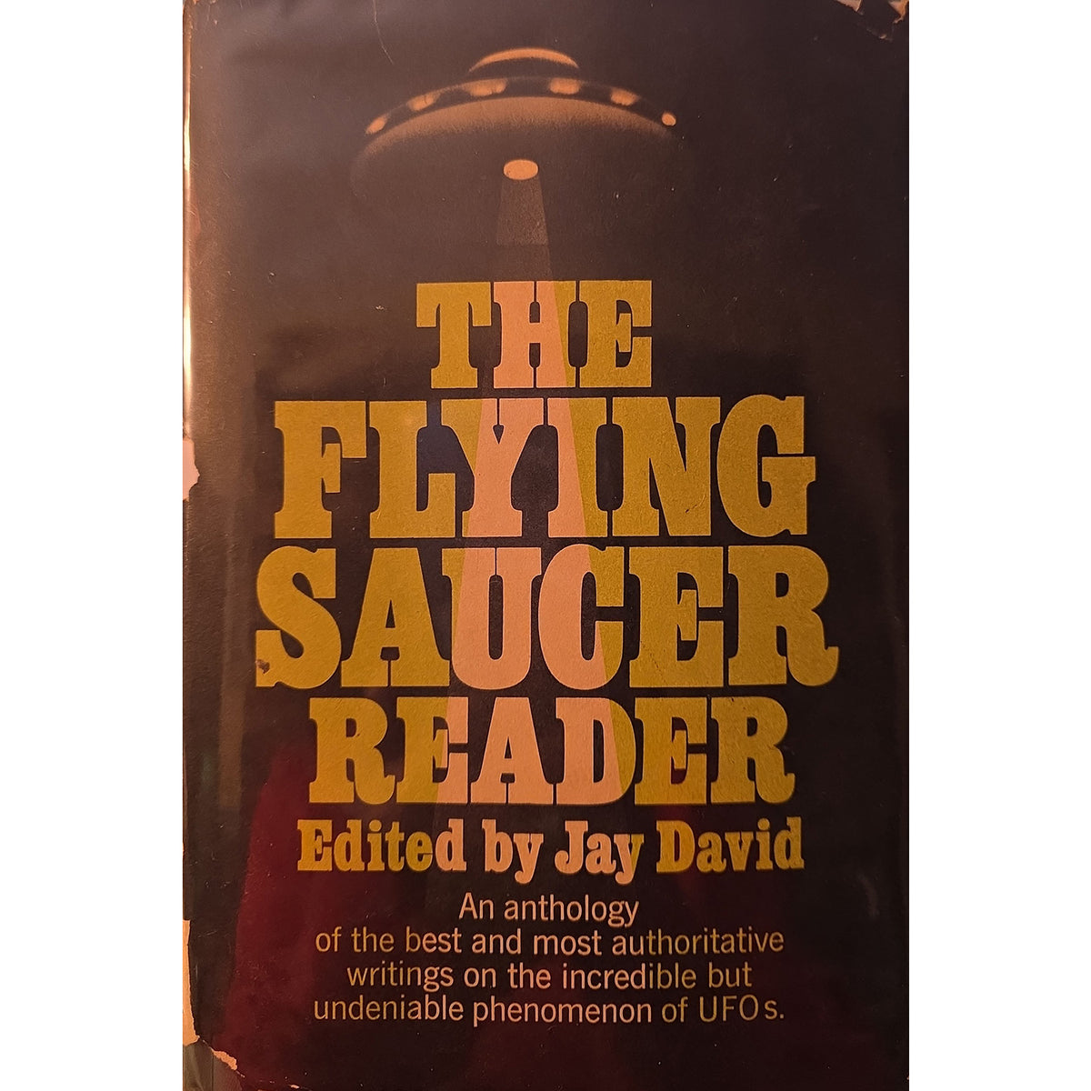 The front cover of the book 'The Flying Saucer Reader' edited by Jay David, featuring a dark brown cover with a silhouette of a flying saucer and large gold title text.