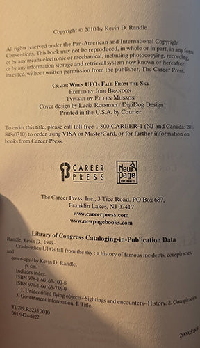 A photographed bookcopyright or publication back cover with printed text, publisher logos, and a New Page mark on a light beige background.