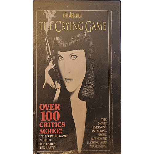 Cover of The Crying Game VHS features a woman with dark hair holding a gun, with bold text highlighting critical acclaim. "Over 100 critics agree" appears in red, praising this Neil Jordan film.