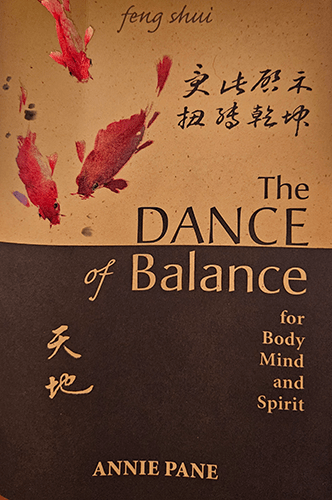 Signed first edition paperback of The Dance of Balance by Annie Pane. Elegant cover with koi fish, Chinese calligraphy, and earthy tones, reflecting themes of feng shui and spiritual balance.