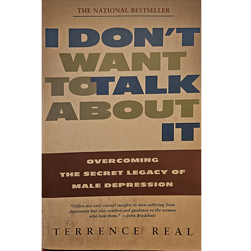 The cover of "I Don't Want to Talk About It" by Terrence Real features bold, overlapping block letters in blue, green, and brown tones, with the subtitle in a brown stripe at the bottom, conveying a serious tone.