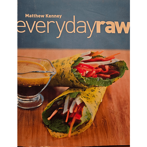 The cover of Everyday Raw by Matthew Kenney features a vibrant, fresh dish, artfully presented against a clean, minimalist background. The title is prominently displayed in bold letters, with the author's name beneath it, reflecting the book's focus on gourmet raw cuisine