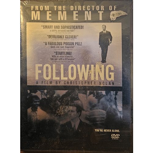 Cover of Following, a DVD film by Christopher Nolan, featuring a suited man against a blurred crowd backdrop. The text emphasizes suspenseful reviews, with "You're Never Alone" as a tagline.