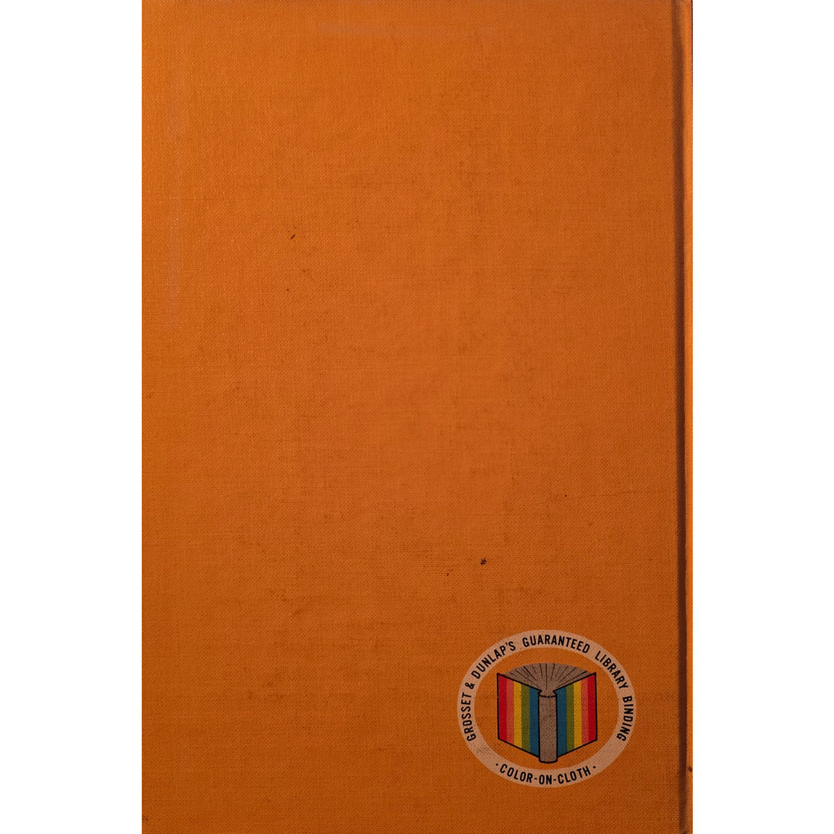 An orange cloth-covered book or notebook cover shown flat against a white background, with a small circular multicolor logo printed near the lower right corner.