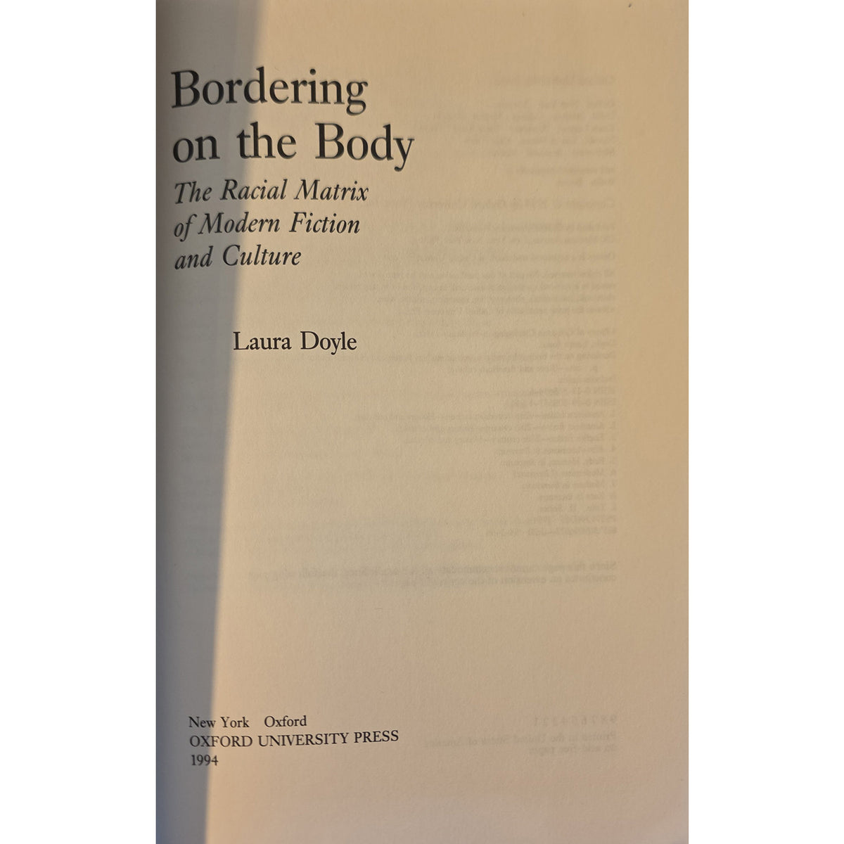 Half title of 'Bordering on the Body: The Racial Matrix of Modern Fiction and Culture' by Laura Doyle, published by Oxford University Press, featuring a minimalist beige and brown design with black text.
