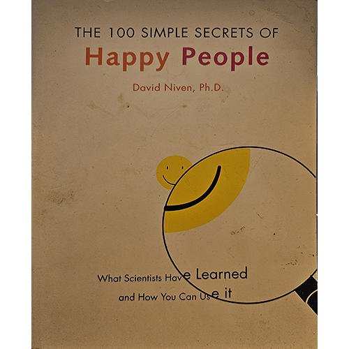 The book cover features a minimalist design with a magnifying glass highlighting a smiling face, representing the pursuit of happiness. The title is in bold, with a clean, straightforward aesthetic.