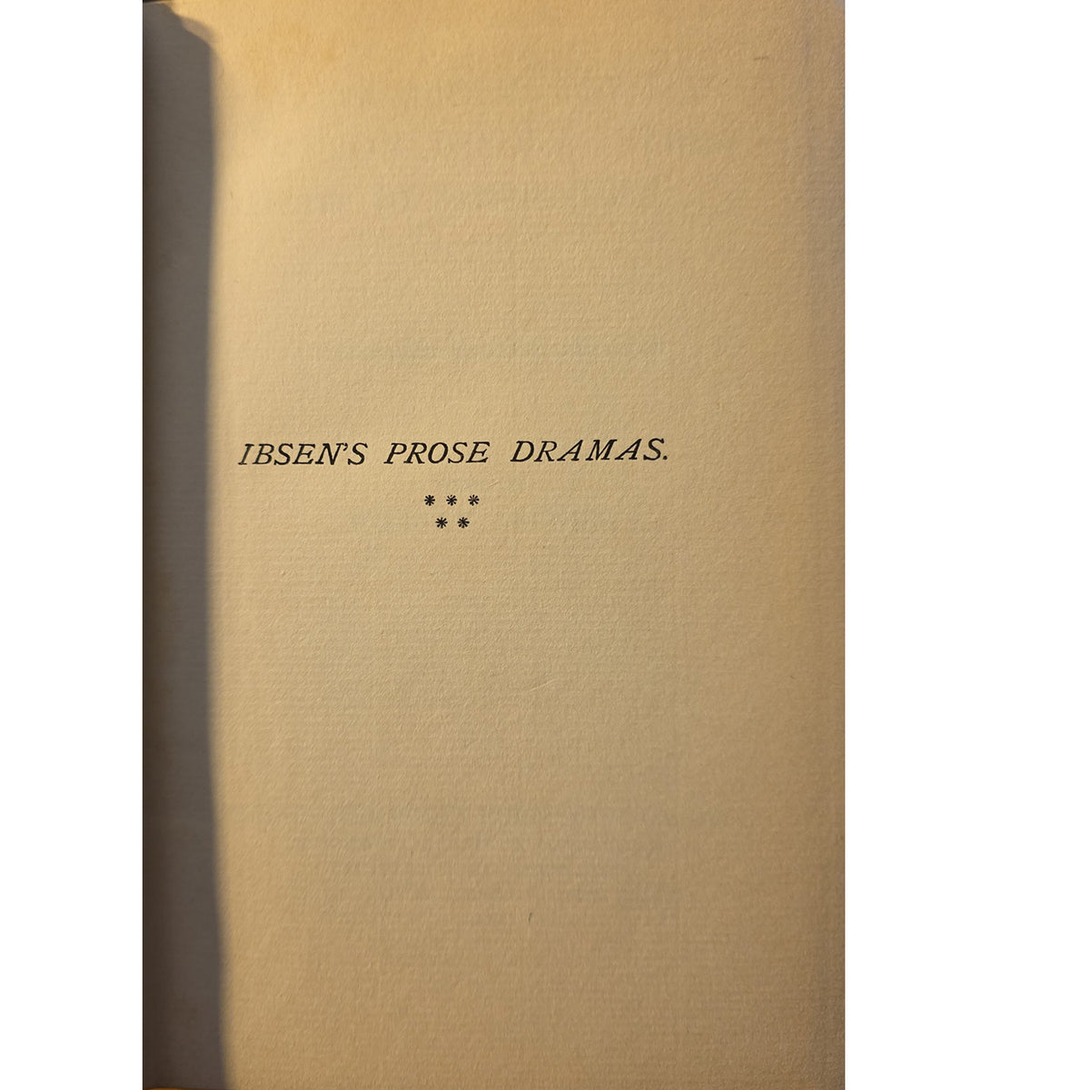 A close-up of a book cover or printed page with the title 'IBSEN'S PROSE DRAMAS.' centered on a warm beige background.