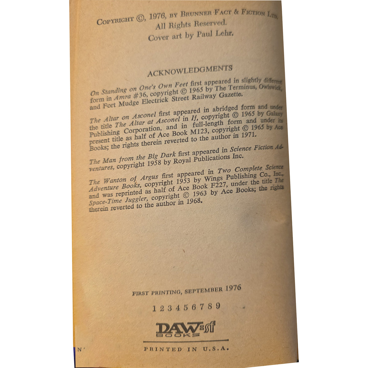 vintage paperback book, showing copyright and acknowledgment text on aged tan paper with a small 'DAW' logo at the bottom.