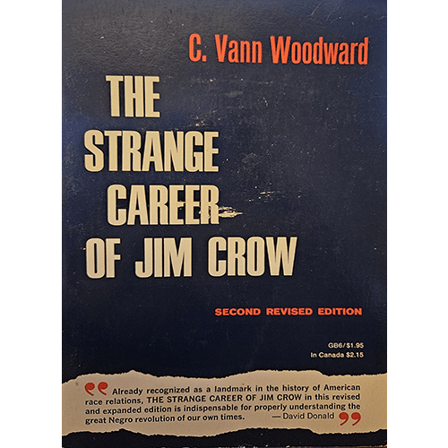 Cover of The Strange Career of Jim Crow by C. Vann Woodward, second revised edition, featuring a bold blue background, large white and red text, and a blurb noting its impact on understanding race relations.