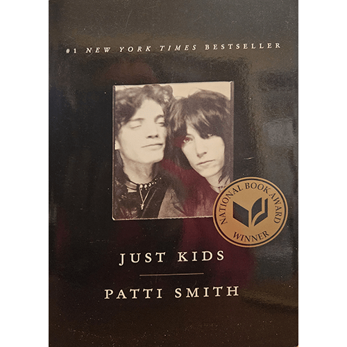 The cover of Just Kids by Patti Smith features a black-and-white photograph of the author with Robert Mapplethorpe, adorned with a gold National Book Award sticker, against a sleek black background