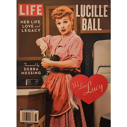 Cover of LIFE magazine's special issue on Lucille Ball, featuring her iconic character in a red checkered apron, with a foreword by Debra Messing and a red heart with "We Love Lucy" text.